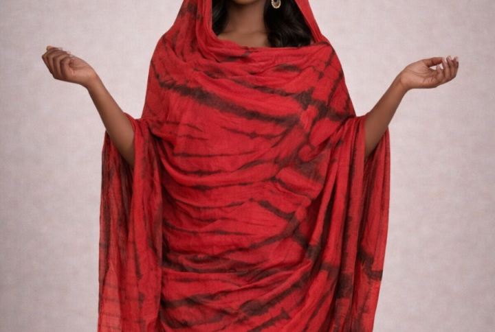 Femme portant une melhfa rouge non cousue tie and dye noir en tissu fluide et élégant